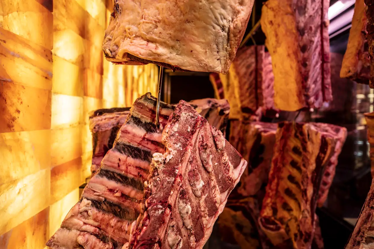 TAR. The Aging Room for Meat Dry-Aging. Himalayan salt wall. Hanging Dry Aged Meat on the hooks.